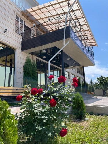 a building with a bunch of red roses in front of it at Royal Ak-Terek Issyk-kul in Ak-Terek