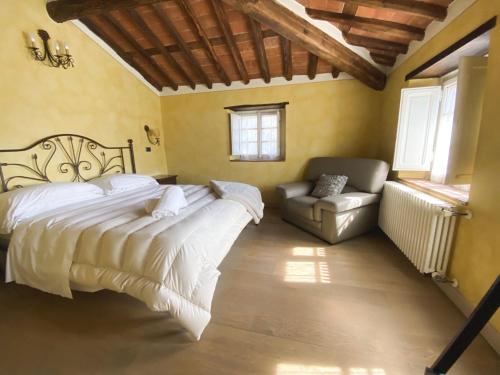 a bedroom with a large bed and a couch at Borgo Giusto Tuscany in Diecimo