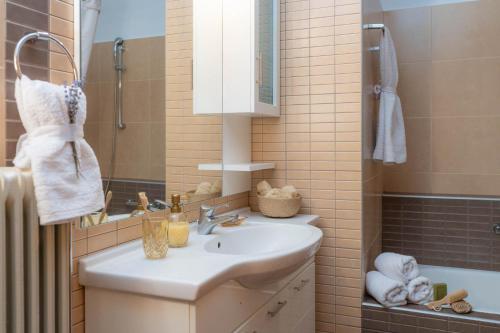 e bagno con lavandino, specchio e vasca. di Postmans Apartment Under Meteora a Kalabaka