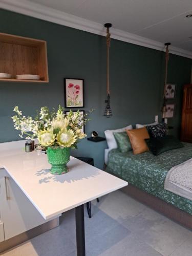 een woonkamer met een bank en een tafel met bloemen bij Greenhouse in Boksburg