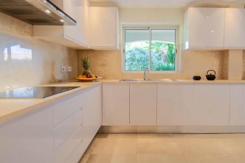 a kitchen with white cabinets and a window at Casa La Vendola in Estômbar