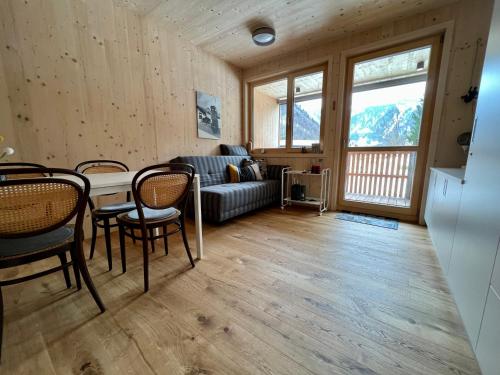 a living room with a couch and a table and chairs at Apartment Eiler - Mellau in Mellau