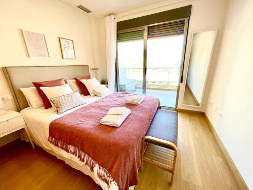 een slaapkamer met een groot bed en 2 handdoeken bij 11 Arenales del sol Beach y piscina in Arenales del Sol