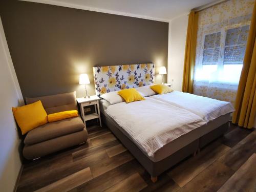 ein Schlafzimmer mit einem Bett, einem Stuhl und einem Fenster in der Unterkunft Schwalbenhof - Urlaub am Bauernhof in Sankt Stefan im Rosental