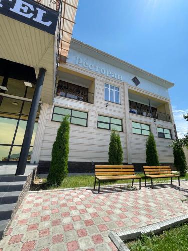 two benches sitting in front of a building at Royal Ak-Terek Issyk-kul in Ak-Terek