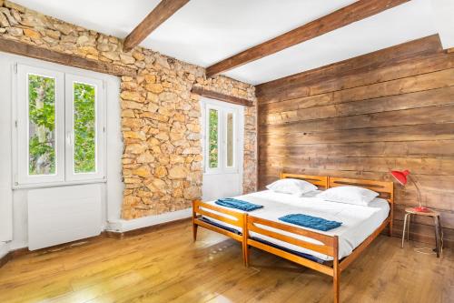 une chambre avec un lit et un mur en bois dans l'établissement Bel appartement, proximité plages Mourillon, à Toulon