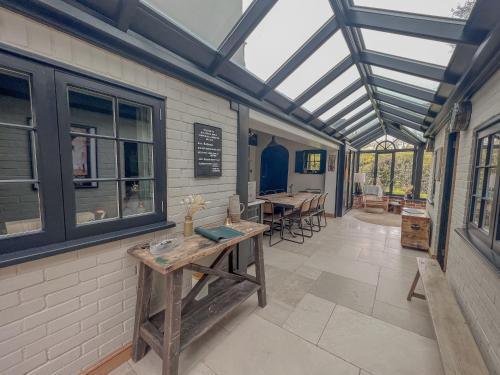 a conservatory with a glass roof and a table at Old School House - Luxury 4 bed holiday home near Norwich, Norfolk in Lingwood