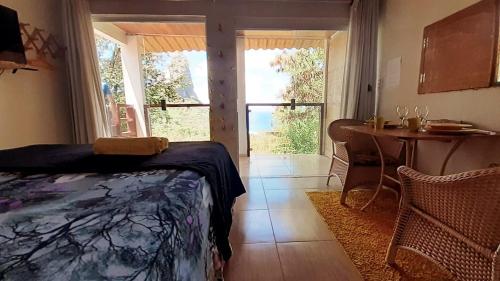 1 dormitorio con cama, mesa y ventana en CASA DE MARCELINO - Hospedagem Domiciliar em Fernando de Noronha en Fernando de Noronha