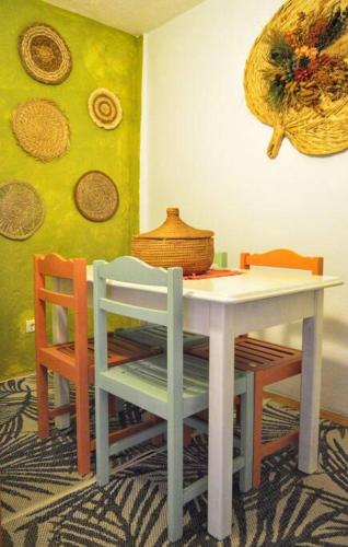 a table with two chairs and a table with a basket on the wall at Casa do Jardim in Montargil