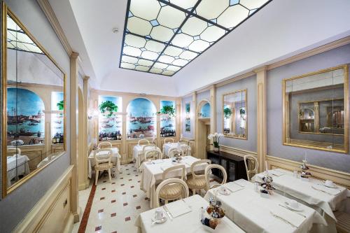 ein Restaurant mit weißen Tischen und Stühlen und einem Dachfenster in der Unterkunft Hotel Colombina in Venedig