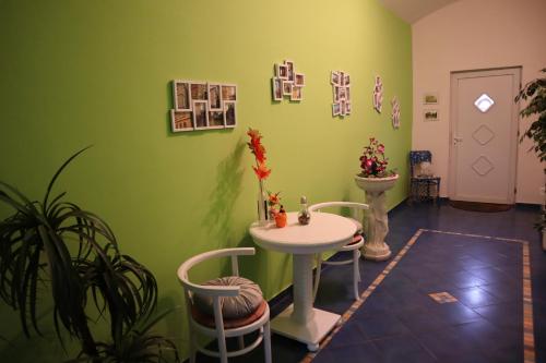 een kamer met een tafel en stoelen en een groene muur bij Olsinky in Ústí nad Labem