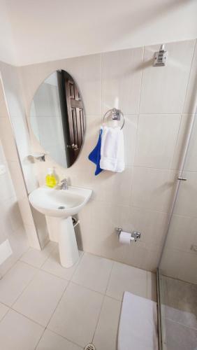 Baño blanco con lavabo y espejo en Hotel Natural Sevgi en Bogotá