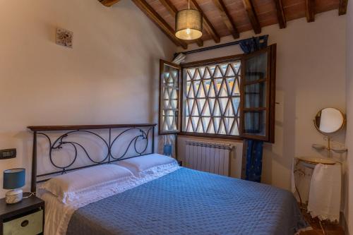 波吉邦西的住宿－Podere le Fonti，一间卧室设有一张床和一个窗口
