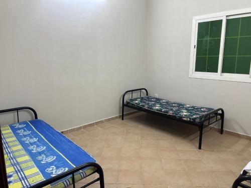 a room with two beds and a window at شقة تبعد عن الحرم ١٠ د in Al Hindāwīyah