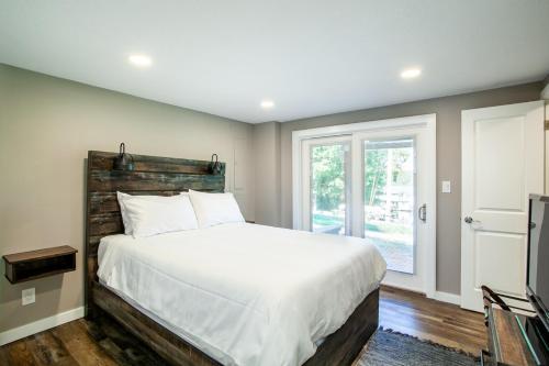 een slaapkamer met een groot bed en een raam bij Tyrrells Pass Lake Access with Hot Tub and Arcade in Lenoir City