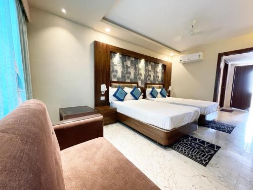 um quarto com uma cama grande e um sofá em Hotel Ambika Palace ! Puri em Puri
