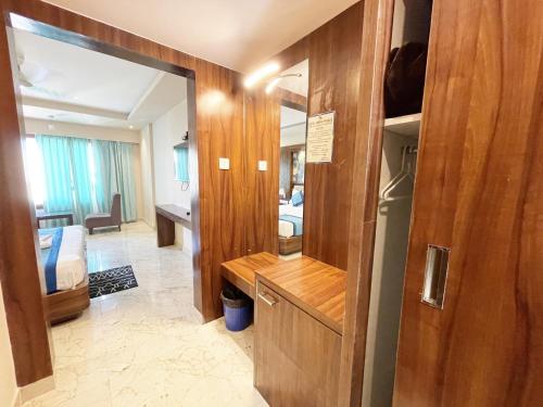 uma sala de estar com um espelho e um quarto em Hotel Ambika Palace ! Puri em Puri