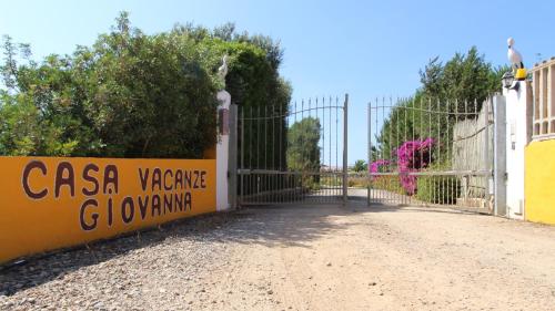 a gate with a sign that reads casa yannis ghovinking at Casa Vacanze Giovanna in SantʼAnna Arresi