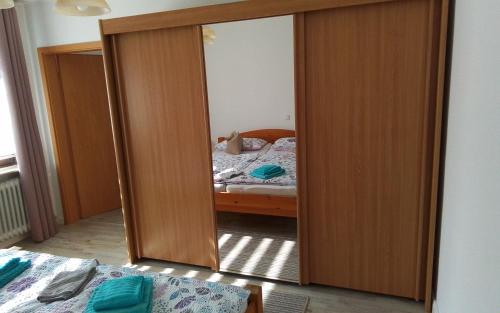 a bedroom with a mirror and a bed in it at Am Luhestrand in Luhdorf