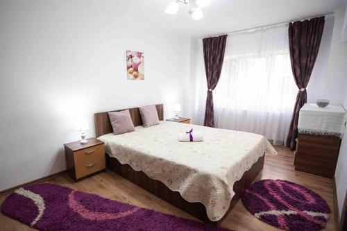 a bedroom with a large bed with a purple rug at Camarad’s house - lovely apartment in Alba Iulia in Alba Iulia