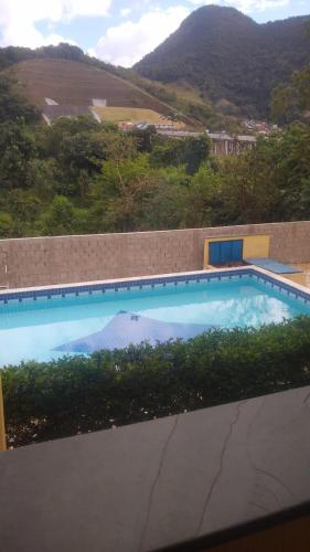 einen Pool mit Bergblick in der Unterkunft Apartamento com Piscina in Caraguatatuba