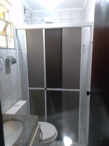 ein Bad mit einer Dusche, einem WC und einem Waschbecken in der Unterkunft Apartamento com Piscina in Caraguatatuba
