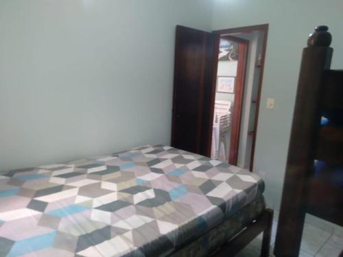 ein Schlafzimmer mit einem Bett mit einem karierten Boden in der Unterkunft Apartamento com Piscina in Caraguatatuba