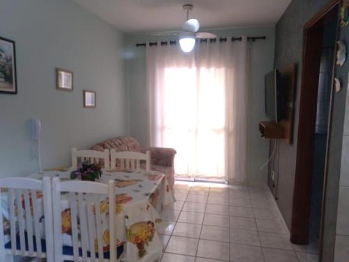 ein Wohnzimmer mit einem Kinderbett und einem Sofa in der Unterkunft Apartamento com Piscina in Caraguatatuba