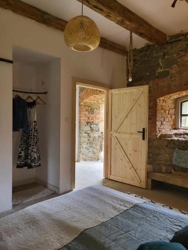 una camera da letto con una porta del fienile e un armadio di Vegan House - kamienny pokój a Międzylesie
