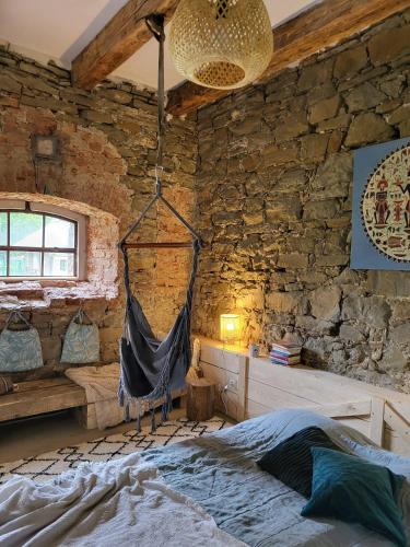 una camera da letto con amaca in una parete in pietra di Vegan House - kamienny pokój a Międzylesie