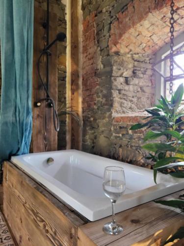 bagno con vasca e bicchiere di vino di Vegan House - kamienny pokój a Międzylesie