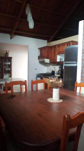 una cocina con una gran mesa de madera con sillas en ALQUILO CASA en gualeguaychú abonas en USD en Gualeguaychú