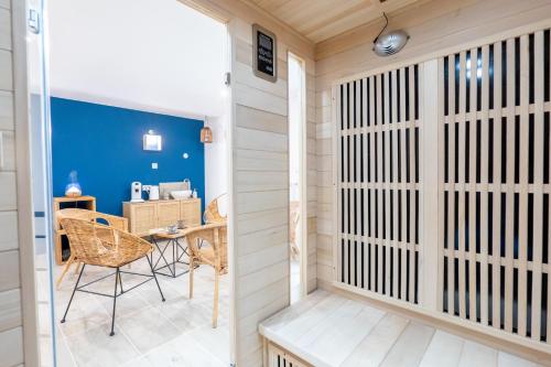a room with a wooden partition with a table and chairs at Plaines-Provence Spa&Sauna in Digne-les-Bains