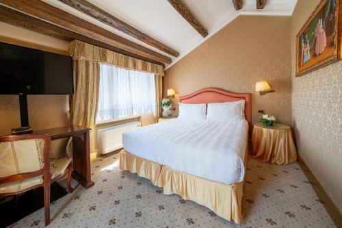 a hotel room with a large bed and a television at Hotel Colombina in Venice