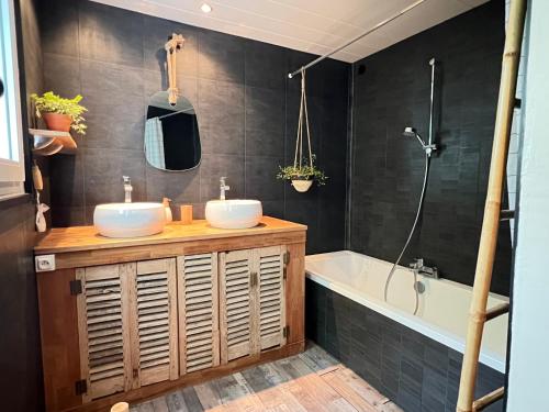 a bathroom with two sinks and a bath tub at La Passerelle Grande maison avec Piscine chauffée in Rivedoux-Plage