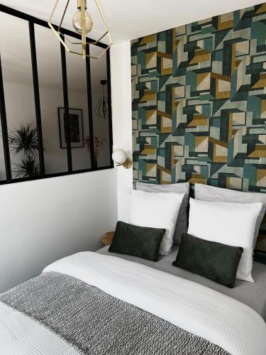 une chambre avec un lit avec des draps blancs et des oreillers verts dans l'établissement Le Ravello proche gare PARTDIEU, à Lyon