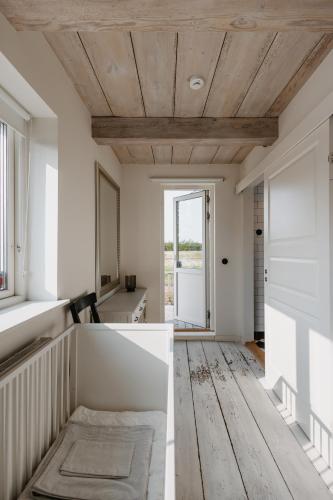 a living room with a wooden ceiling and a window at Rynke gård in Ljungbyhed