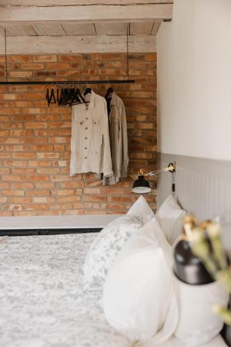 a room with clothes hanging on a brick wall at Rynke gård in Ljungbyhed