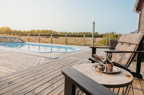 a table with a plate of food on a deck next to a pool at Rynke gård in Ljungbyhed