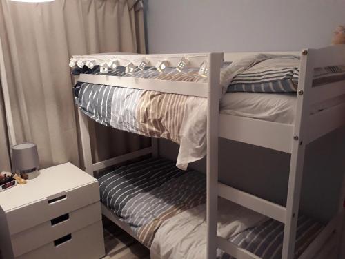 a bedroom with a bunk bed with a desk and a bunk bed at Holiday at Hemsby in Hemsby