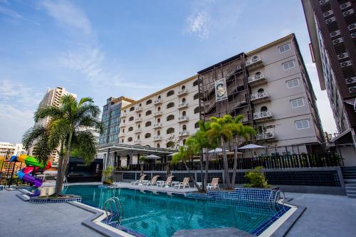 un hotel con piscina frente a un edificio en Sabai Sabana, en Pattaya central