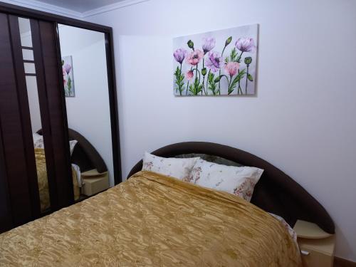 卡胡爾的住宿－Villa Aura，卧室配有一张床,墙上挂着一幅画