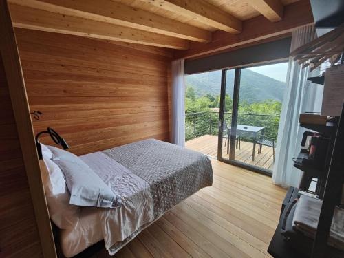 a bedroom with a bed and a large window at Tree House San Giorgio in Solagna