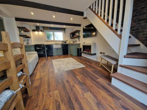 uma grande cozinha com uma escada e uma sala de estar em The Loft at Foxglove Lodge 