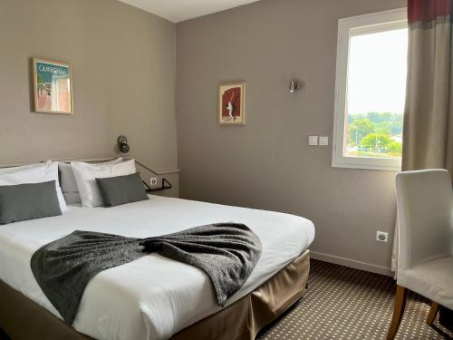 a bedroom with a large bed with a blanket on it at Hôtel Ursula in Cambo-les-Bains