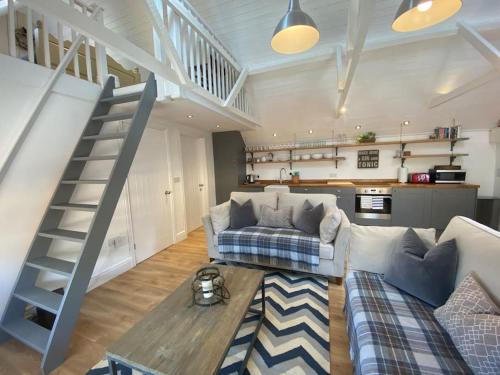 a living room with a couch and a staircase at The Coach House in Shootend