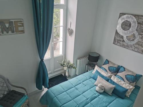 een slaapkamer met een blauw bed en een raam bij Gîte des trois plages 6 personnes in Lancieux