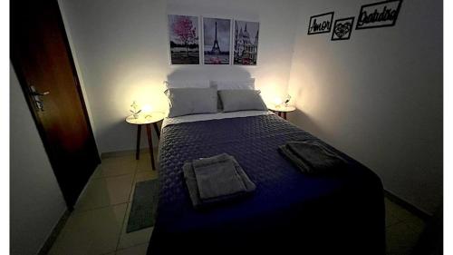 um quarto com uma cama com um edredão azul em Apartamento Perto do Aeroporto em Lauro de Freitas