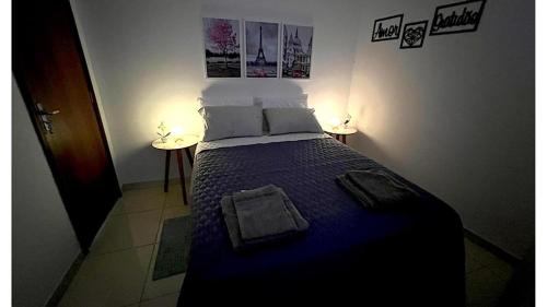 a bedroom with a bed with a blue comforter at Apartamento Perto do Aeroporto in Lauro de Freitas