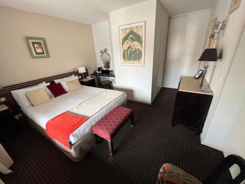 カンボ・レ・バンにあるHôtel Ursulaのベッドと赤い椅子があるホテルの部屋